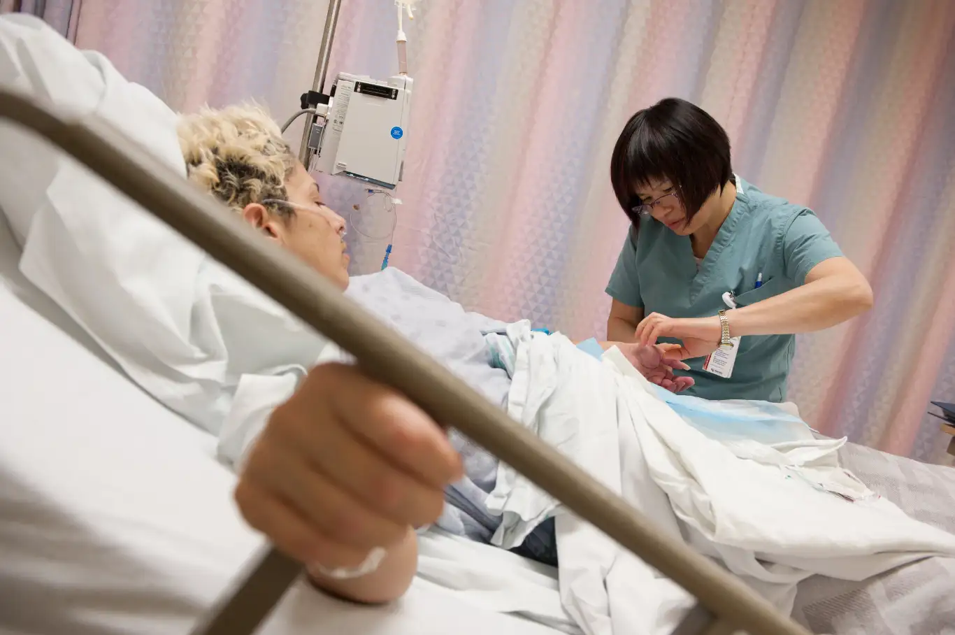 Nurse examines patient in bed