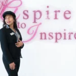 Business woman poses in front of sign